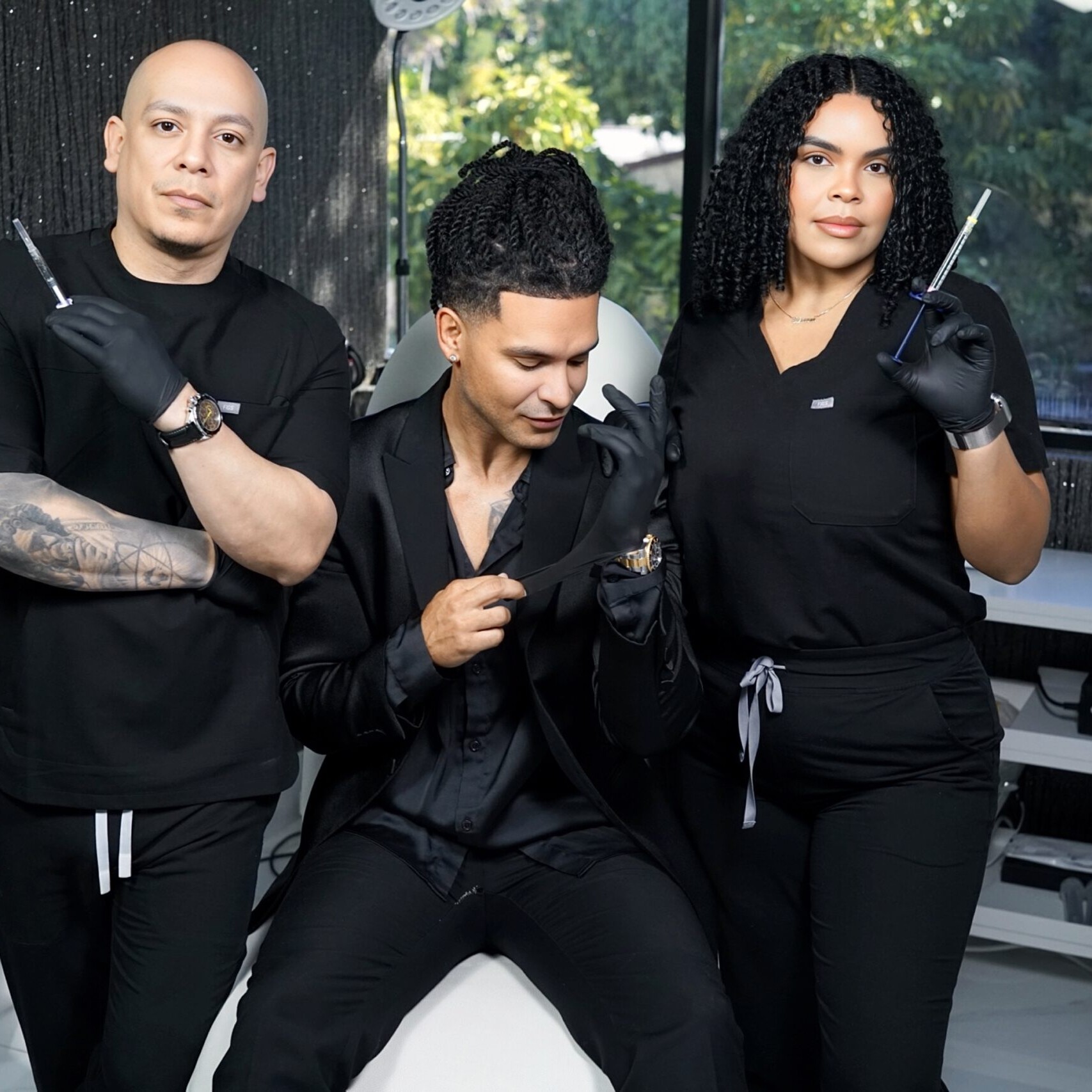 Three people in a beauty salon hold aesthetic tools