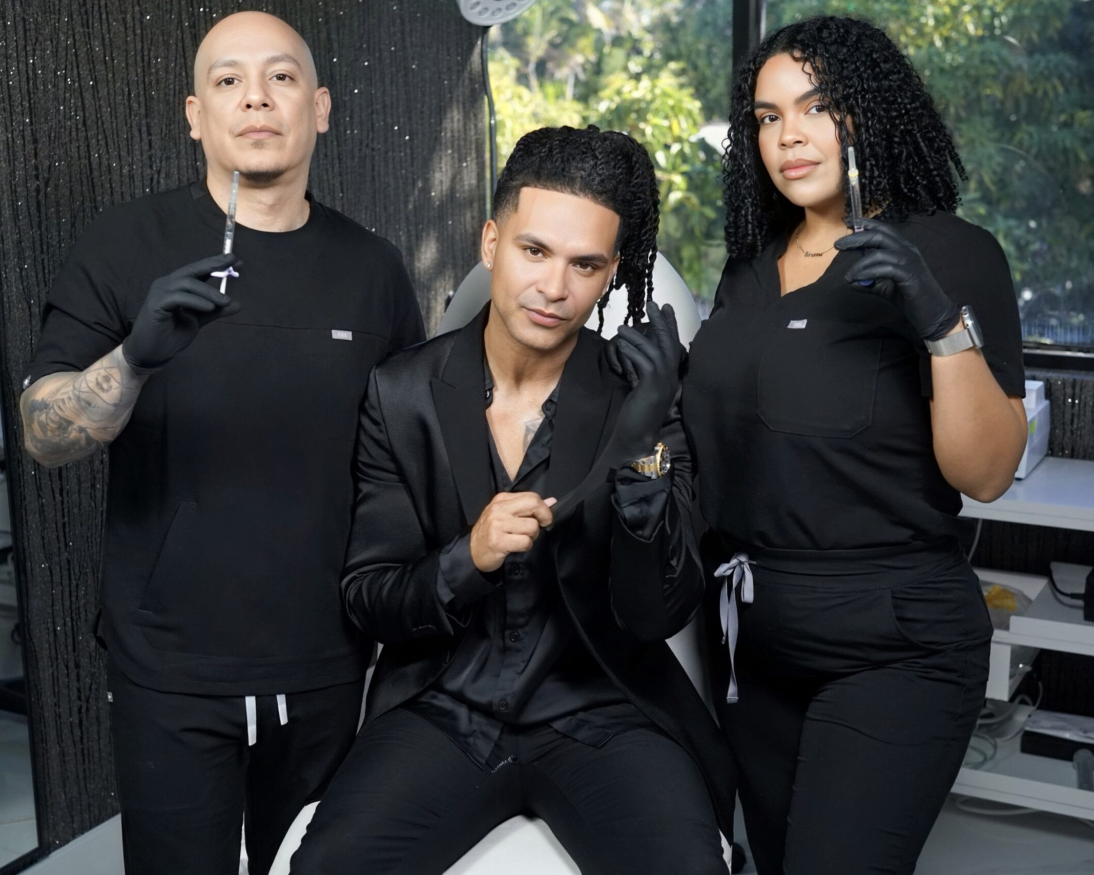Three people in a beauty salon hold aesthetic tools